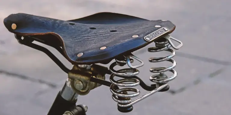Blue leather bicycle saddle with metal coil springs and rivets