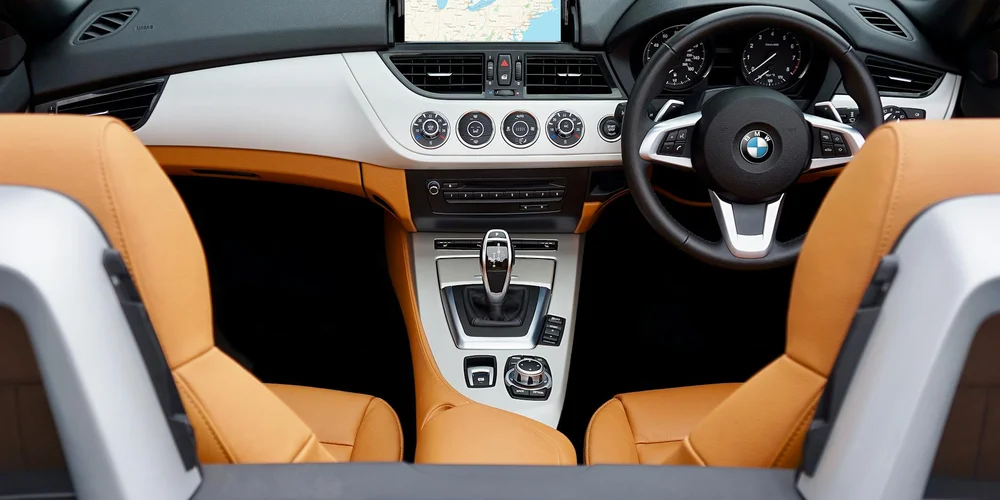 BMW interior featuring orange leather seats and a sunlit dashboard, illustrating heat-related leather discoloration.