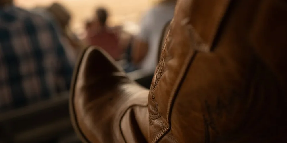 Close-up of a brown leather boot showing stitching and texture.
