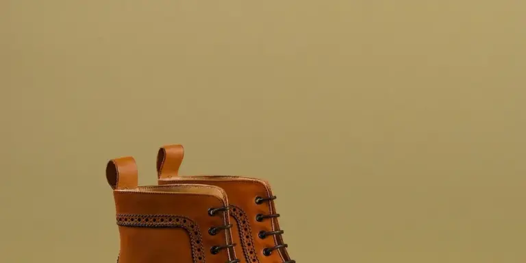 Brown leather lace-up boot with visible stitching and pull tabs