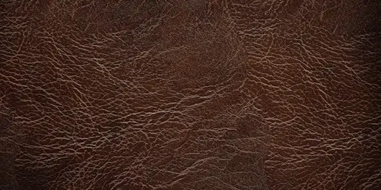 Close-up of a textured brown leather surface with natural grain and creases.