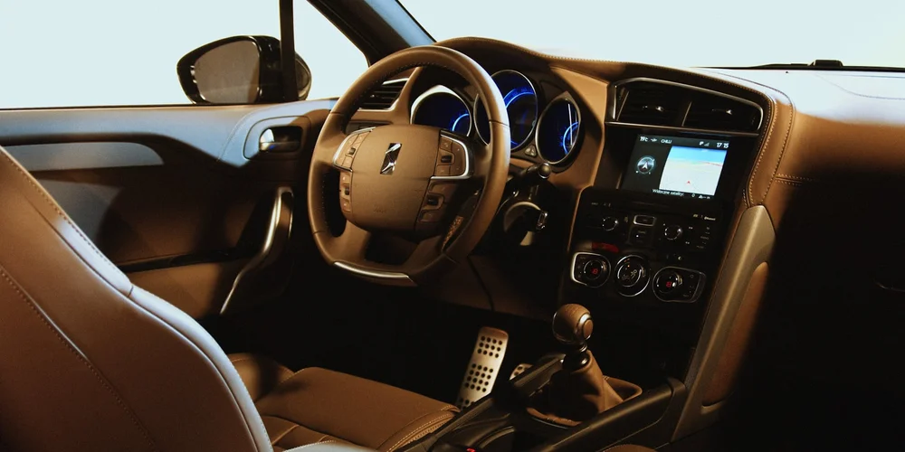 Close-up view of a car interior with brown leather seats and a leather-wrapped steering wheel