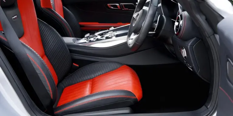 Interior of a luxury car featuring red and black leather seats and a steering wheel.