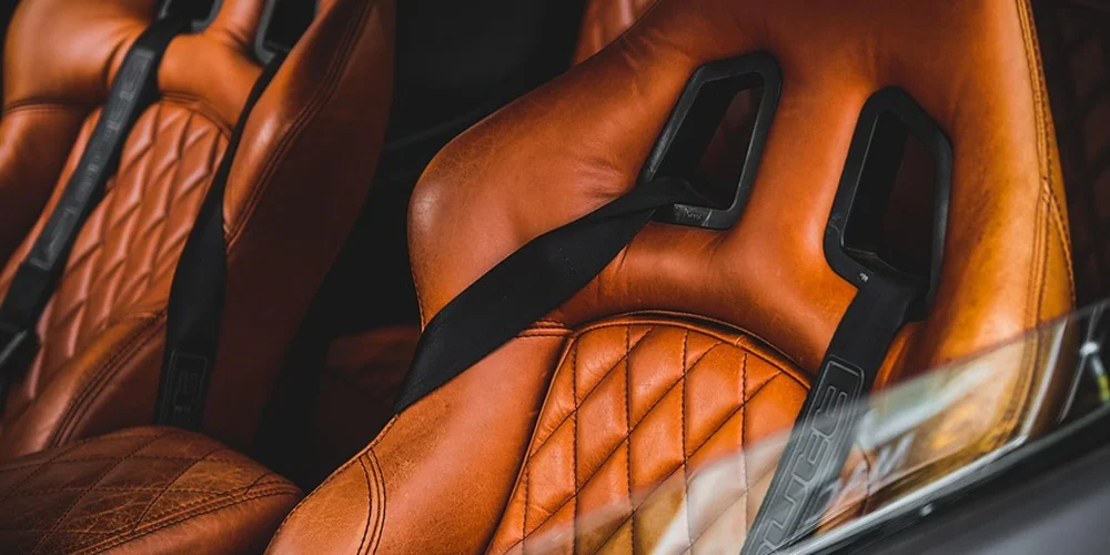 How Do You Remove Stubborn Stains Like Ink, Coffee, or Grease from Car Leather Seats Without Damaging the Material?