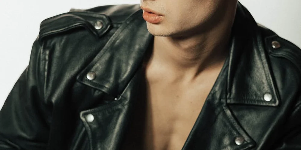 Close-up of a person wearing a black leather jacket, cropped at the shoulders and neck.