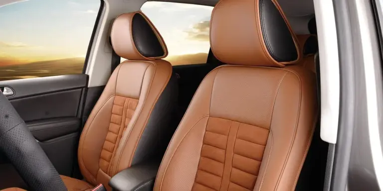 Brown faux leather car seats inside a vehicle with headrests.
