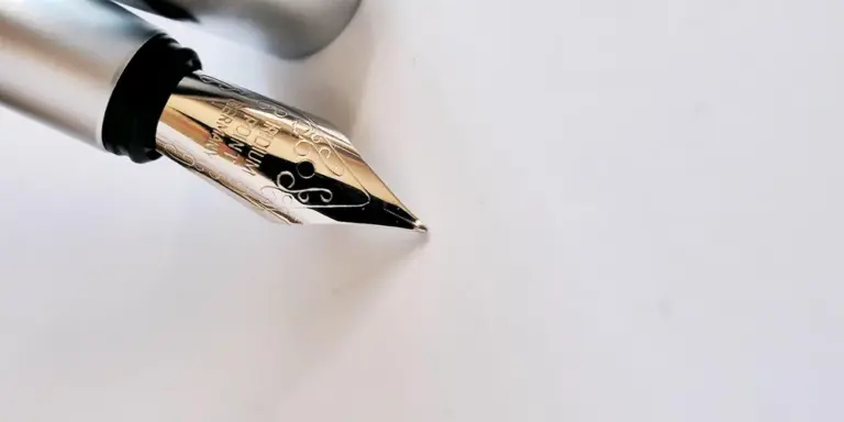 Close-up of a fountain pen nib on a white surface