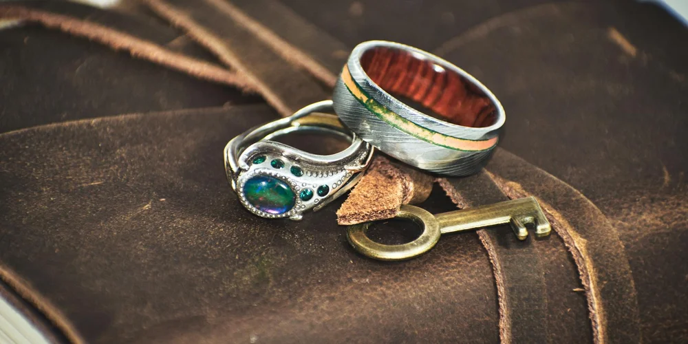 Close-up of dark brown leather with visible grain and texture, with a vintage ring and key resting on its surface.