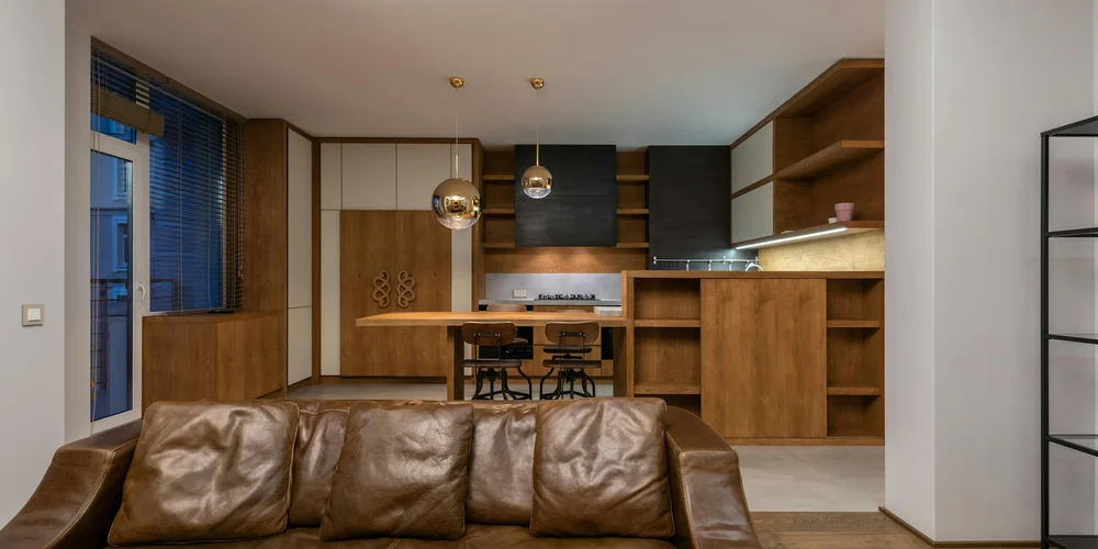 Brown leather sofa in a modern open-plan kitchen and dining area.