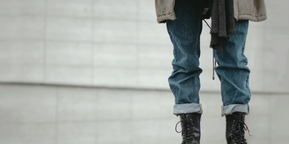 Leather boots worn by a person with rolled denim cuffs