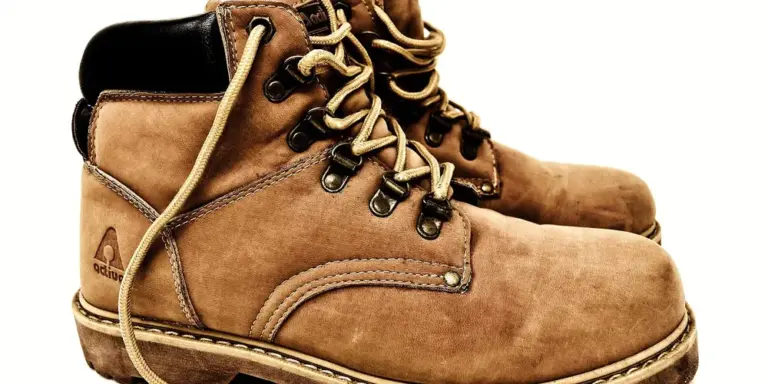 Close-up of brown leather hiking boots with laces and reinforced stitching, ready for outdoor use in wet conditions.