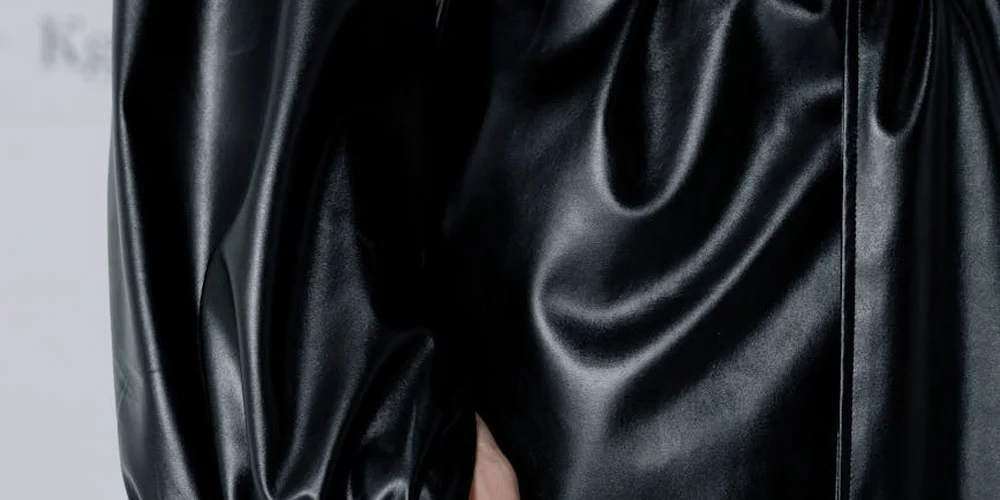 Close-up of a glossy black leather surface with natural wrinkles