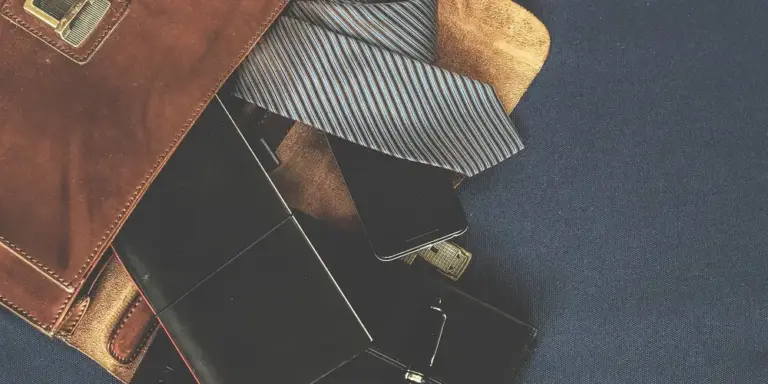 Assorted leather goods, including wallets and belts, arranged on a dark surface to illustrate leather care.