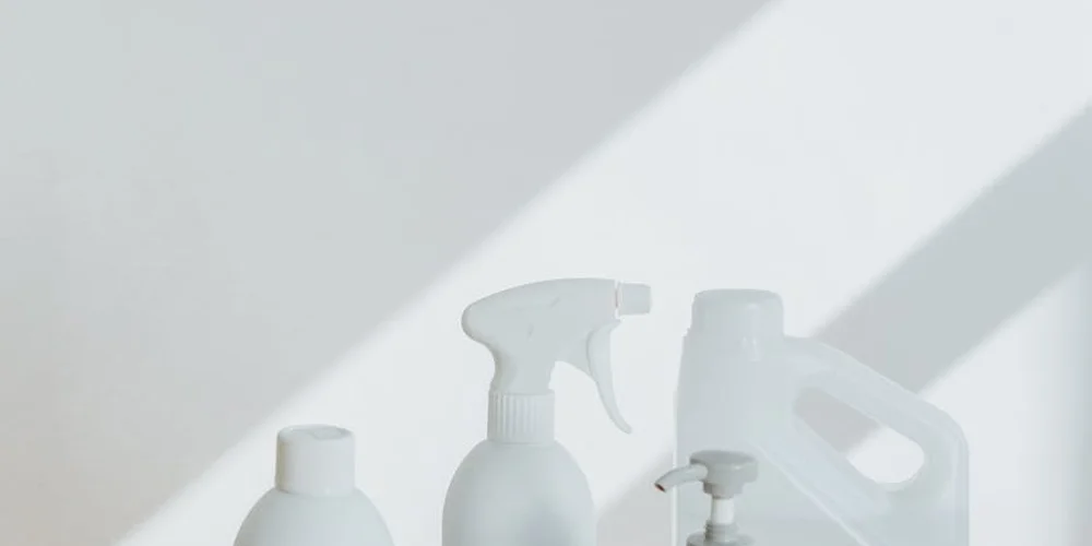Assorted leather care bottles and spray bottle on a light surface, ready for saddle soap use and leather cleaning.