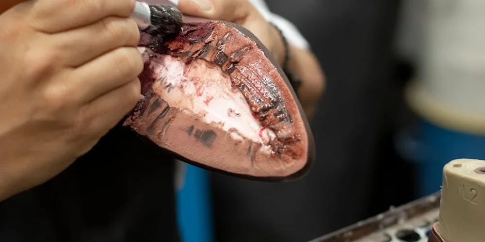 Close-up of a damaged leather surface being treated with a leather dye repair kit