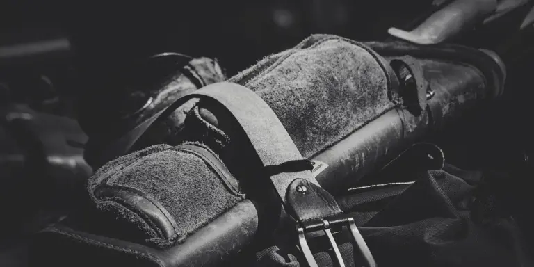 Grayscale photo of a leather bag with straps and stitching, illustrating the leather material discussed in the dye and stain transfer removal guide.