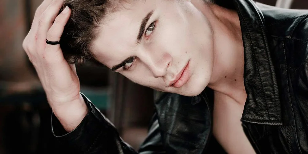 Person wearing a black leather jacket, looking at the camera.