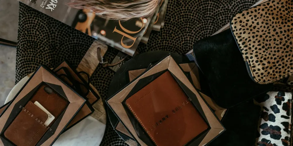 Close-up of assorted leather goods and packaging materials laid out on a surface, suggesting leather items that could develop mold.