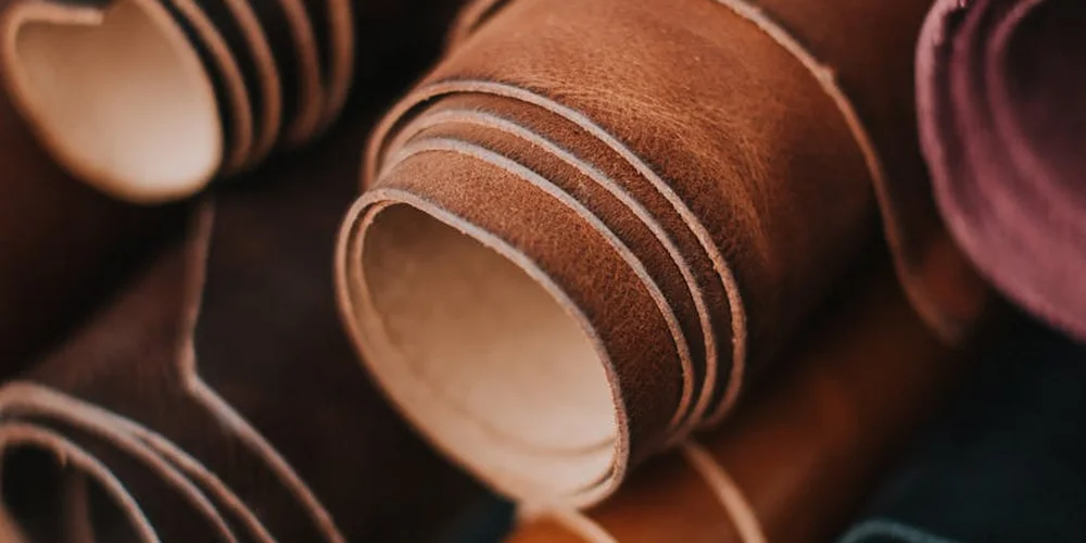 Close-up of rolled leather strips in brown tones, showcasing leather texture