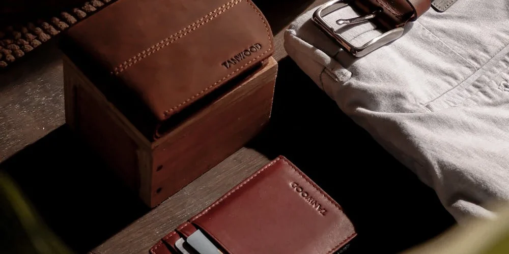 Close-up of leather belts and a wooden block used for hole punching, highlighting a clean setup for precise leatherwork