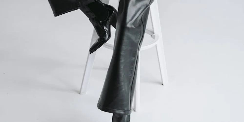 Close-up of a black leather boot on a white surface, ready for mink oil application