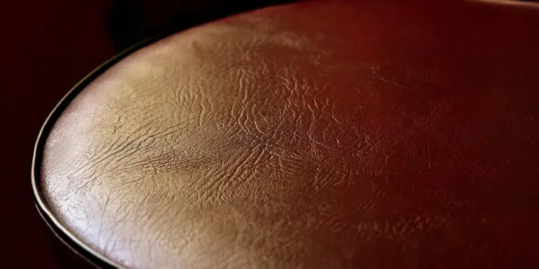 Close-up of brown leather texture with natural grain and subtle sheen.