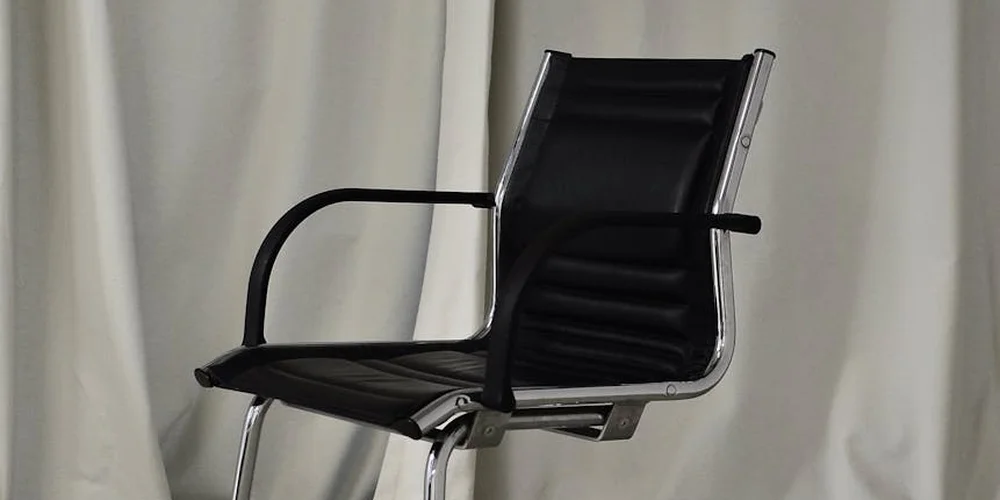 Black leather office chair with a metal frame.