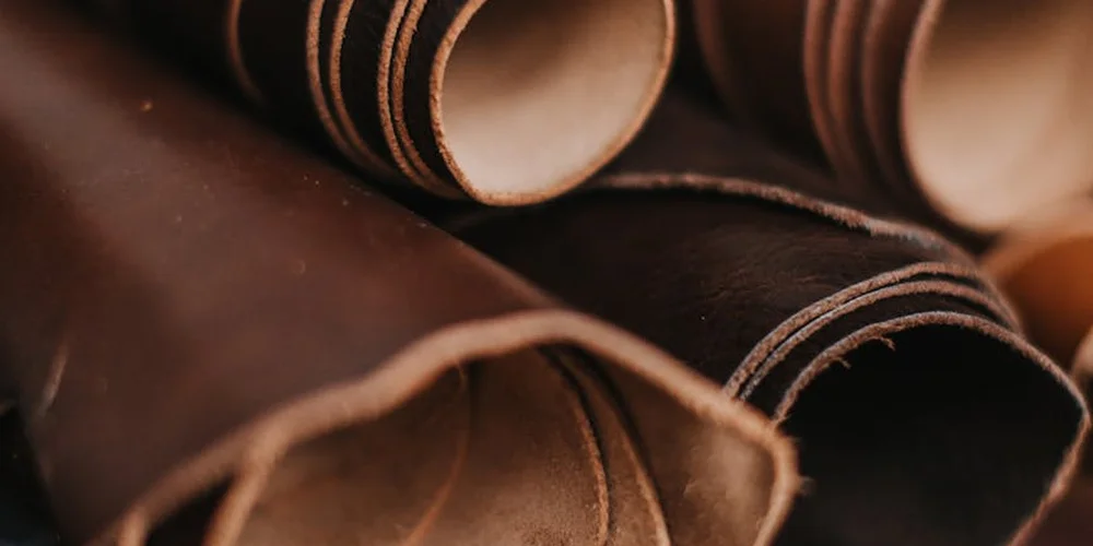 Close-up of rolled brown leather hides with visible edges and texture.