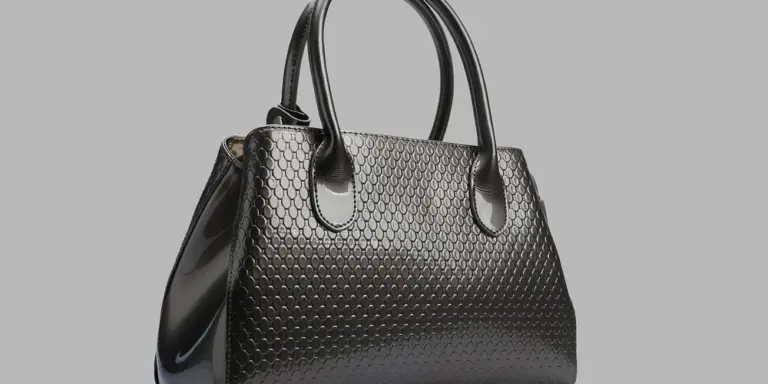 Black textured leather handbag on a gray background