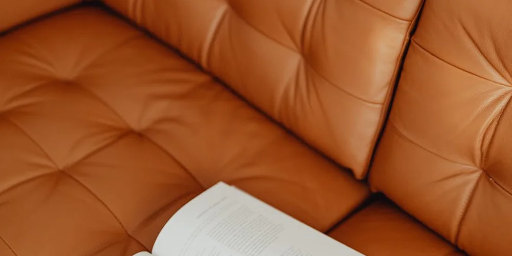 Close-up of a tan tufted leather sofa.