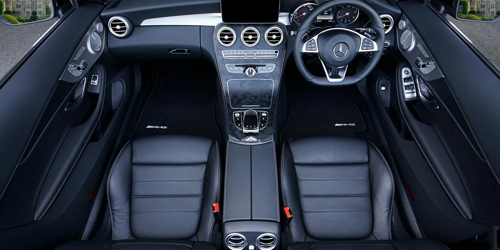 Luxurious black leather car seats with a modern dashboard and steering wheel.
