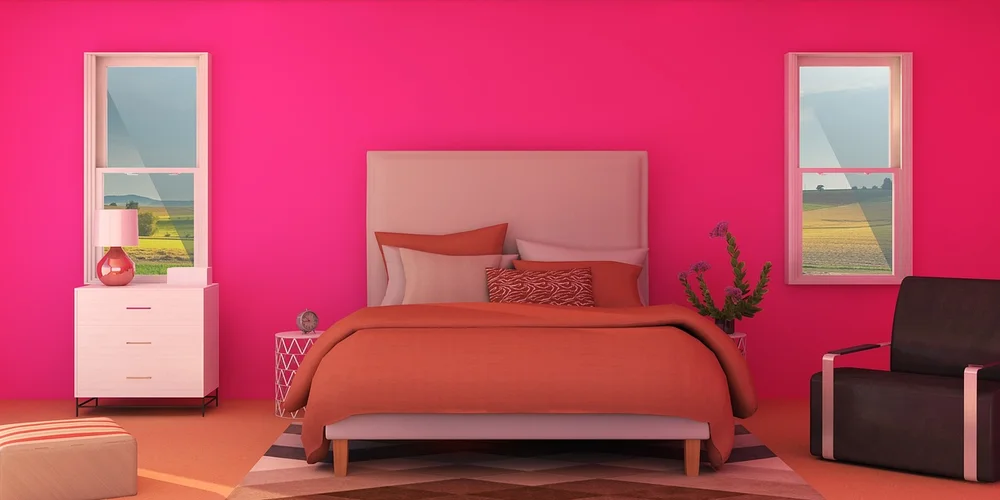Bright pink bedroom with a beige bed, orange-brown bedding, two white nightstands, a black chair, and two windows.