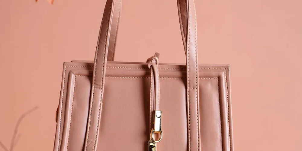 Soft pink leather handbag on a peach background
