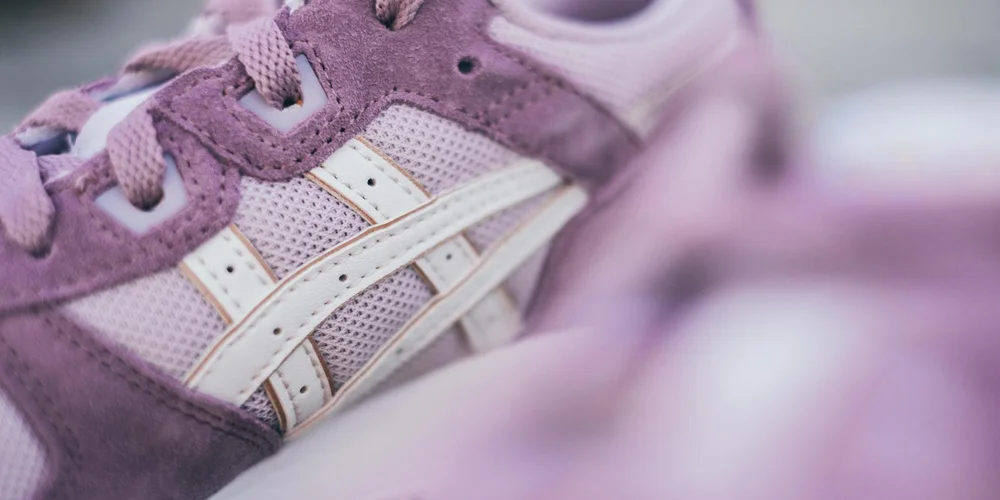 Close-up of purple suede sneakers with white accents