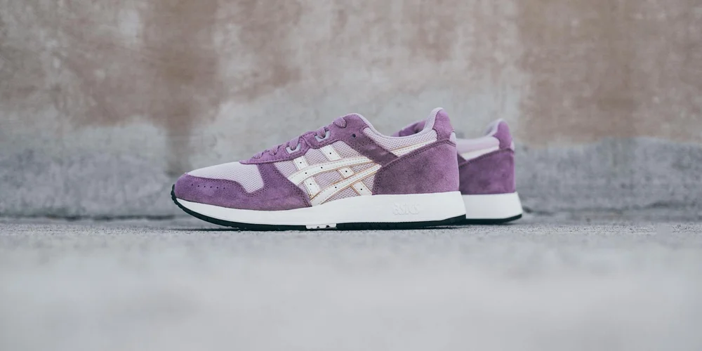 Pair of purple suede sneakers resting on a concrete surface