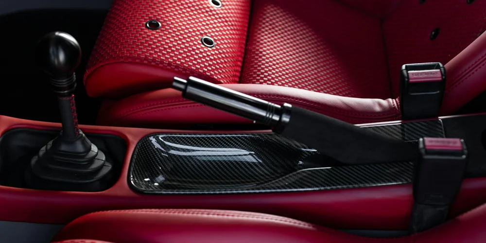 Red faux-leather car seats with perforations and black center console trim