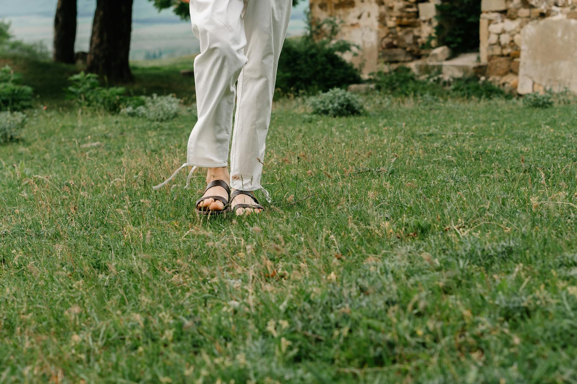 Smiling woman with a towel wrapped around her head, applying foamy face wash in a bathroom.