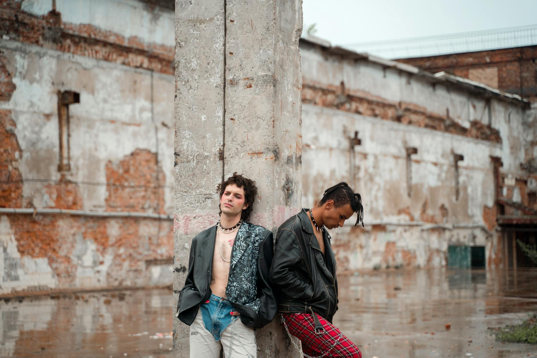 Smiling woman with a towel wrapped around her head, applying foamy face wash in a bathroom.