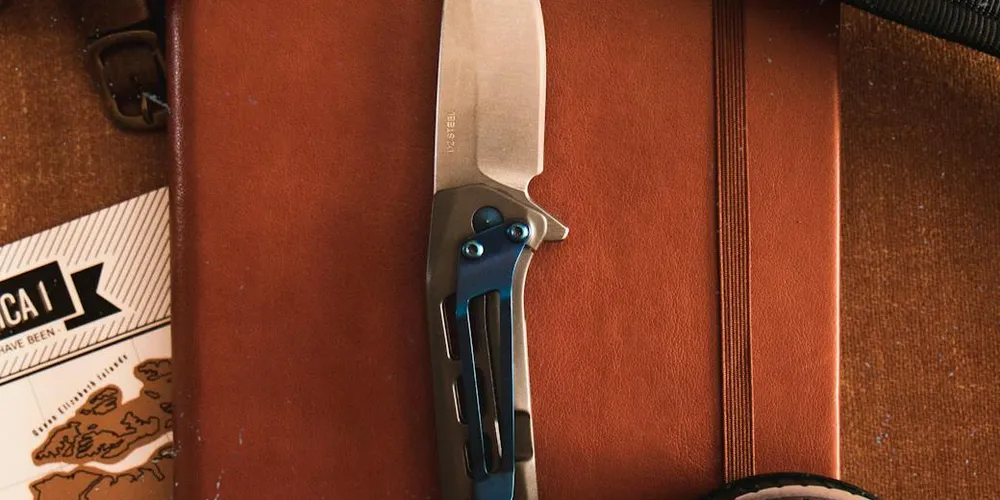 Close-up of a folding knife resting on a weathered brown leather surface with a leather case, illustrating materials involved in leather restoration.