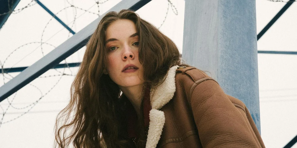 Model wearing a brown sheepskin jacket outdoors