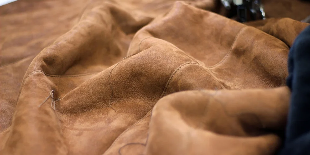 Close-up of a brown suede jacket showing soft nap and stitching