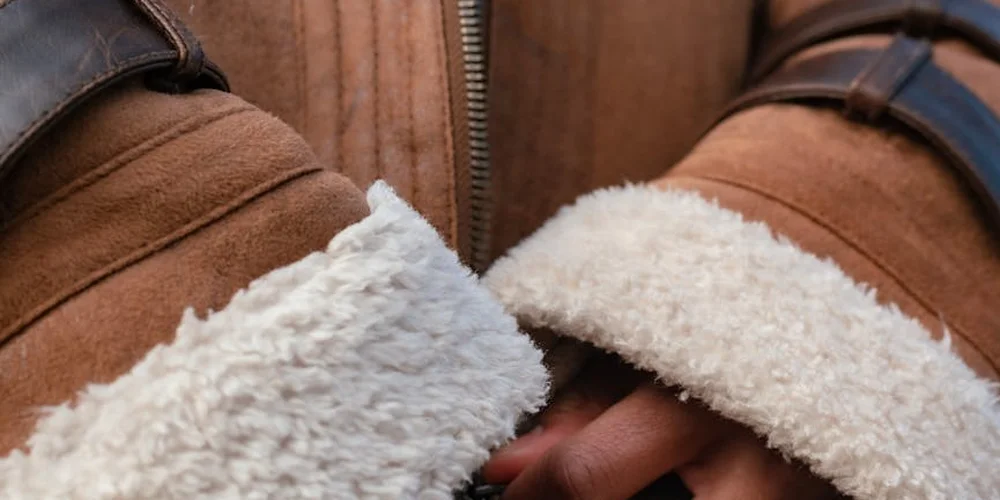 Close-up of a brown suede jacket with white shearling lining