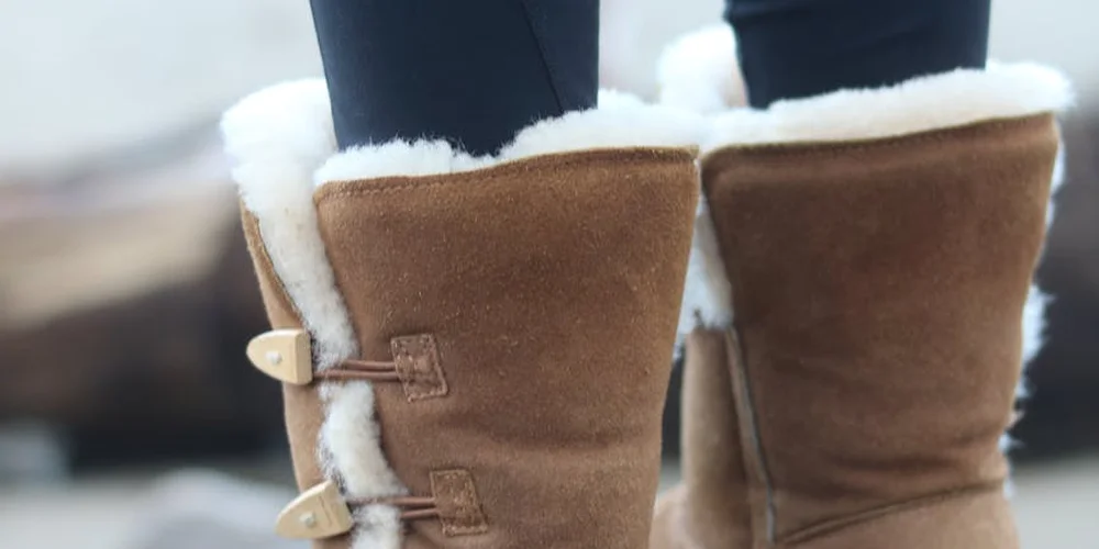 Close-up of brown suede boots with white shearling lining, highlighting the nap and texture of suede
