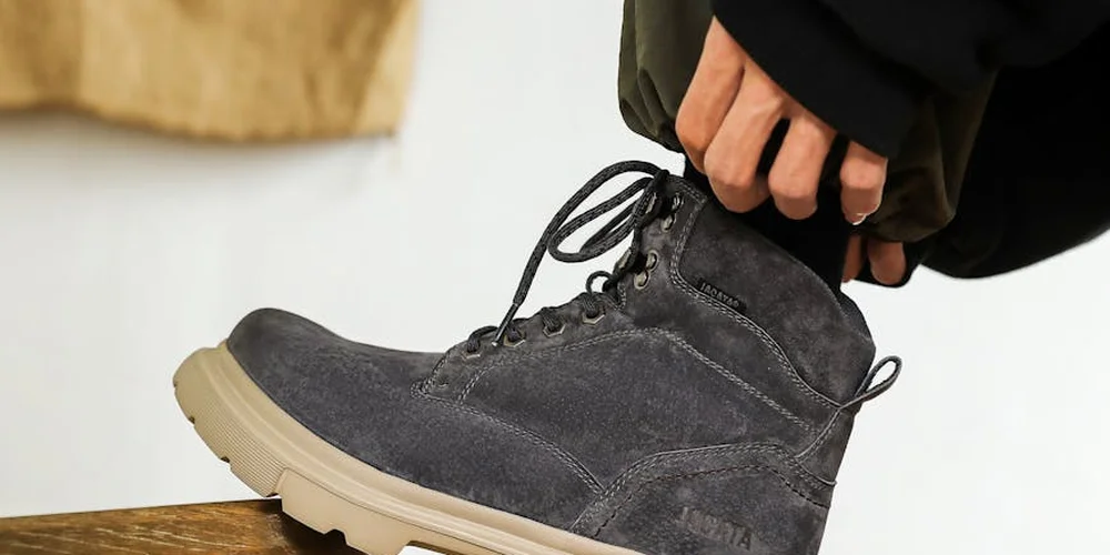 Close-up of gray suede boots with laces, showing texture and wear.