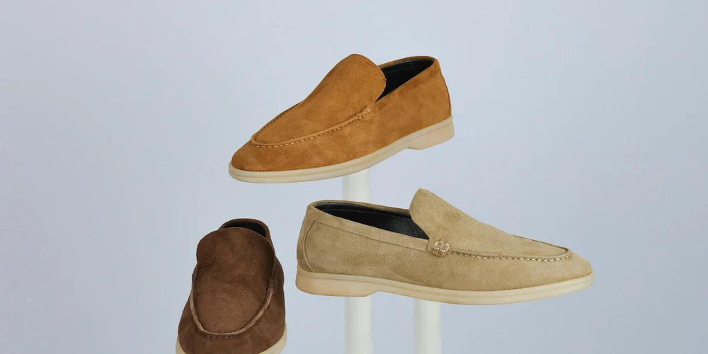 Three suede shoes in tan and brown tones displayed on a light background.