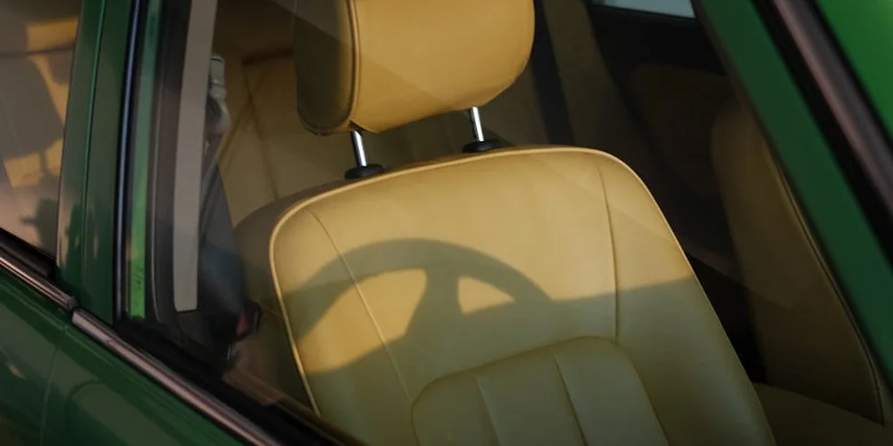 Tan leather car seat with headrest in a car interior, ready for ink-stain removal steps