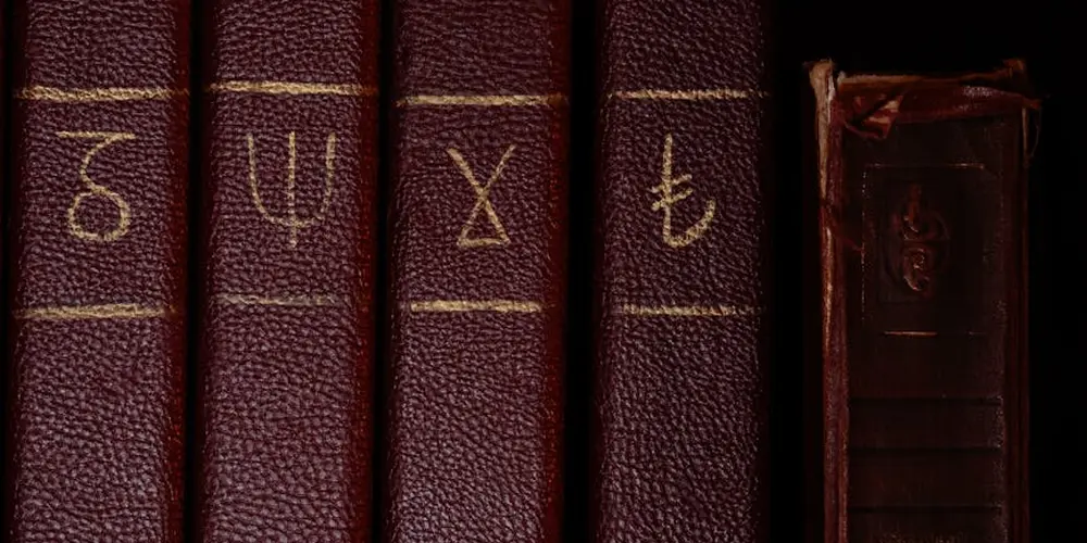 Close-up of aged, dark leather-bound volumes with gold tooling on the spine
