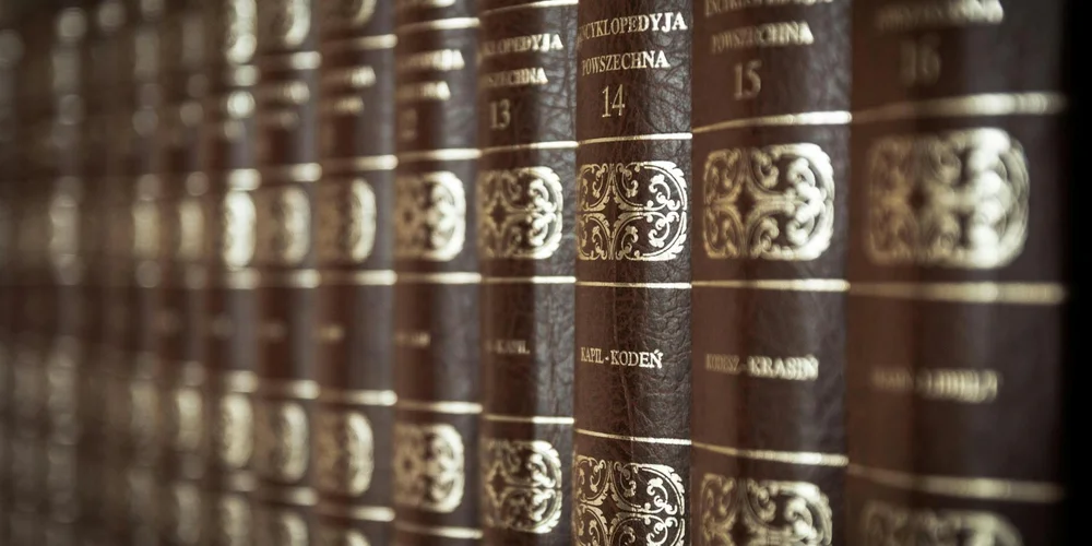 Close-up of vintage leather-bound books with gold-embossed spines.