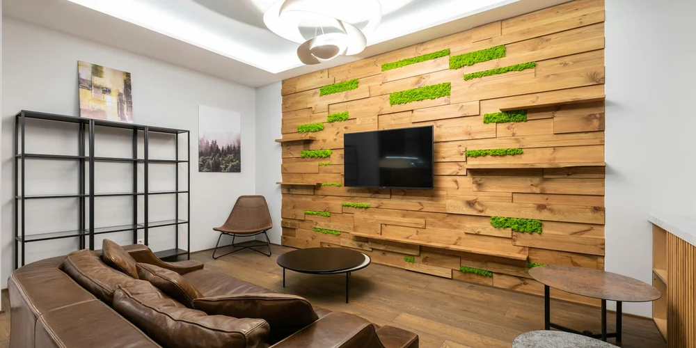 Modern living room with a brown leather sofa and a wood-paneled accent wall.